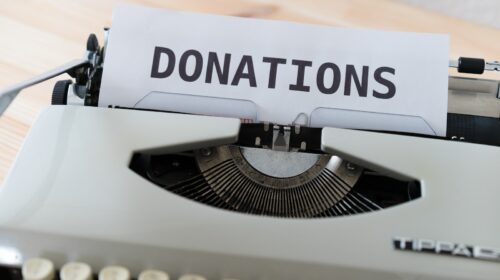 a close up of a typewriter with a donation sign on it